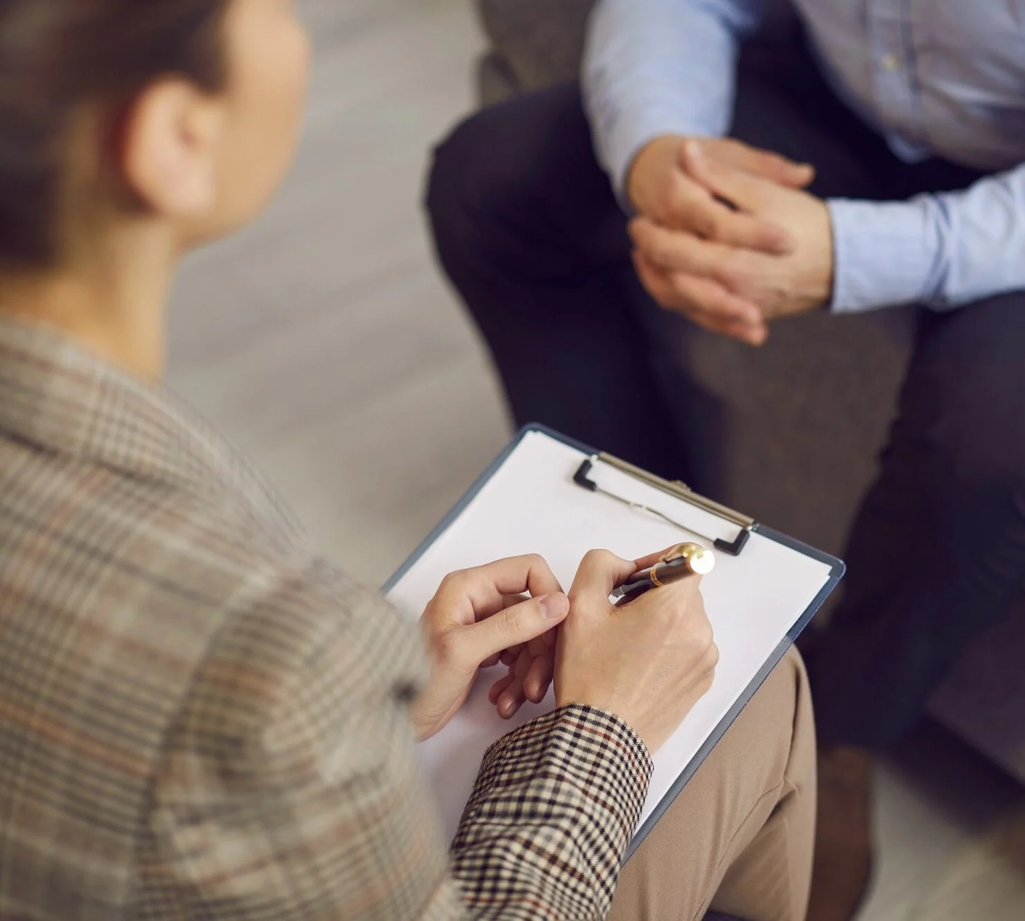 Woman therapist with a clipboard and a sheet of paper talking